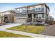 Charming two-story home with a well-maintained lawn, stone accents, and a two-car garage at 9283 Sedalia St, Commerce City, CO 80022