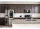 Modern kitchen with stainless steel appliances, dark cabinetry, and a granite countertop island at 9283 Sedalia St, Commerce City, CO 80022