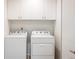 Bright laundry room with a washer and dryer set, white cabinets, and a sleek design at 9283 Sedalia St, Commerce City, CO 80022