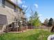 Expansive backyard featuring a spacious wooden deck, lush green lawn, mature trees, and an inviting outdoor space at 10273 Salida St, Commerce City, CO 80022