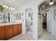 Bright bathroom with wood cabinets, decorative mirrors, a walk in closet and an arched entranceway at 10273 Salida St, Commerce City, CO 80022