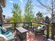 Relaxing deck area with comfortable seating, stylish outdoor rug, and scenic views of lush greenery and trees at 10273 Salida St, Commerce City, CO 80022