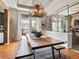 Bright dining room with a rustic table, bench seating, unique light fixture, and seamless glass wall at 10273 Salida St, Commerce City, CO 80022