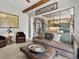 Comfortable living room featuring a decorative coffee table, wood beams, and views into the dining area at 10273 Salida St, Commerce City, CO 80022