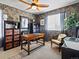 Comfortable office with wallpaper, a ceiling fan, a wooden desk, and a decorative chair at 10273 Salida St, Commerce City, CO 80022
