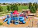 Colorful playground with slides and climbing structures, surrounded by green space in the community at 10273 Salida St, Commerce City, CO 80022