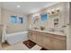 Modern bathroom with dual vanities, soaking tub, tile flooring, and stylish lighting fixtures at 613 Iowa St, Golden, CO 80403