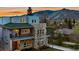 A modern, multi-story home with a stone facade and balconies offers stunning views of the surrounding mountains at sunset at 613 Iowa St, Golden, CO 80403