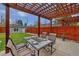 Beautiful outdoor patio area with pergola, dining set, and a lush green lawn at 613 Iowa St, Golden, CO 80403