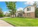 Well-maintained lawn and landscaping complement the brick and siding of this two-story home at 8474 E Otero Cir, Centennial, CO 80112
