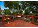 Outdoor deck with chairs and table, illuminated with string lights, and surrounded by lush greenery at 13693 W Utah Cir, Lakewood, CO 80228