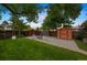Spacious backyard featuring a shed, patio set, mature trees, and a swing at 13693 W Utah Cir, Lakewood, CO 80228