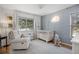 Cozy Bedroom featuring a light-filled room, light wood crib, comfortable glider chair and inviting decor at 13693 W Utah Cir, Lakewood, CO 80228