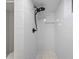 Sleek shower featuring white subway tile, black fixtures, and a convenient niche for storage at 13693 W Utah Cir, Lakewood, CO 80228