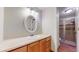 Bathroom features a wood vanity, sink with oval mirror and a tiled shower with glass doors at 8752 E Amherst Dr # D, Denver, CO 80231