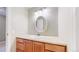 Bathroom features a wood vanity, sink with oval mirror and modern light fixture at 8752 E Amherst Dr # D, Denver, CO 80231