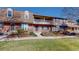 This charming townhome features a mix of brick and siding, a balcony and a green front lawn at 8752 E Amherst Dr # D, Denver, CO 80231