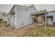 Exterior view of the backyard with a covered patio, grass, rocks, and light blue siding at 16179 E Rice Pl # B, Aurora, CO 80015