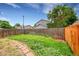 Grassy backyard with a stone pathway surrounded by a wooden fence and a vibrant lawn at 5275 Cody St, Arvada, CO 80002