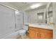 Well-lit bathroom featuring a shower-tub combo and vanity with wooden cabinets at 5275 Cody St, Arvada, CO 80002