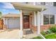 Inviting front entrance featuring brick accents, covered porch, and gray garage door at 5275 Cody St, Arvada, CO 80002