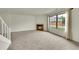 Spacious living room with a brick fireplace, large window, and neutral carpet at 5275 Cody St, Arvada, CO 80002