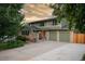 Exterior of green home with three-car garage and landscaped front yard at 11039 W 65Th Way, Arvada, CO 80004