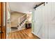 Hallway with hardwood floors, a staircase, and a sliding barn door adds character to the space at 11039 W 65Th Way, Arvada, CO 80004