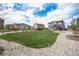 Expansive backyard featuring lush green lawn, landscaped garden beds, and a cozy pergola at 1616 Metcalf Dr, Erie, CO 80516