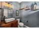 Stylish powder room featuring modern sink, wood vanity, and decorative wall art at 1616 Metcalf Dr, Erie, CO 80516