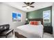 Cozy bedroom with green accent wall, ceiling fan, and views from the window at 1616 Metcalf Dr, Erie, CO 80516