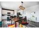 Dining area and kitchen with stainless steel appliances, white cabinets, and a decorative light fixture at 1616 Metcalf Dr, Erie, CO 80516
