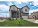 Two story home with manicured front lawn, mature landscaping and covered front porch. Integrated two car garage at 1616 Metcalf Dr, Erie, CO 80516
