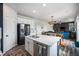 Bright kitchen with white cabinets, stainless steel appliances, and an island featuring a sink and quartz countertop at 1616 Metcalf Dr, Erie, CO 80516