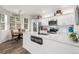 Bright kitchen with white cabinets, stainless steel appliances, breakfast nook, and modern countertops at 5231 S Greens Cir, Littleton, CO 80123
