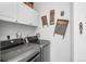 Laundry room featuring a front-loading washer and dryer with upper cabinets at 5231 S Greens Cir, Littleton, CO 80123