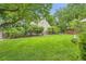 The backyard has a large lawn, mature trees, wooden fence, and a partial view of the house at 7708 S Krameria Ct, Centennial, CO 80112