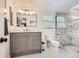 Renovated bathroom with a gray vanity, hexagon tiled floor, and a glass-enclosed shower with marble-like wall tiles at 7708 S Krameria Ct, Centennial, CO 80112