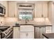 Well-appointed kitchen with farmhouse sink, stainless steel appliances, and custom backsplash at 7708 S Krameria Ct, Centennial, CO 80112