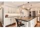 Spacious kitchen with white cabinetry, an island with bar seating, and modern lighting at 7708 S Krameria Ct, Centennial, CO 80112
