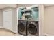 The laundry room has a washer, a dryer, folding table, overhead storage and modern appliances at 7708 S Krameria Ct, Centennial, CO 80112