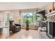 Bright living room featuring wood floors, a brick fireplace, and a view of the outdoor patio at 7708 S Krameria Ct, Centennial, CO 80112