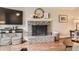 Cozy living room features a brick fireplace, wood floors, and a mounted television at 7708 S Krameria Ct, Centennial, CO 80112