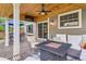 This covered patio has a ceiling fan, an outdoor television, seating, and a fire pit table at 7708 S Krameria Ct, Centennial, CO 80112
