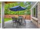 The patio has a table, seating, an umbrella, a brick wall, and a grass lawn at 7708 S Krameria Ct, Centennial, CO 80112