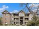 Three-story condo building featuring stone accents, private balconies and well-maintained landscaping at 8039 Lee Dr # 2, Arvada, CO 80005