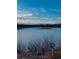 A scenic winter view of a tranquil pond surrounded by dried grasses and distant mountains at 8039 Lee Dr # 2, Arvada, CO 80005