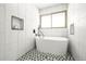 Bright bathroom featuring a standalone tub, unique tile flooring, and a window for natural light at 11710 Spruce Canyon Cir, Golden, CO 80403