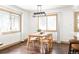 A dining room featuring a table, four chairs, hardwood flooring, natural light, and modern light fixture at 11710 Spruce Canyon Cir, Golden, CO 80403