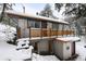 Charming home with unique wood railings, snow-covered landscape, nestled in the woods at 11710 Spruce Canyon Cir, Golden, CO 80403